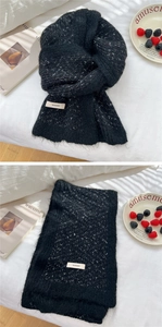 Detail of black and white knitted scarf texture with BONOGEED brand label and soft fabric