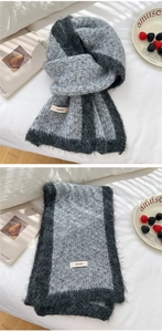 Detail of soft mohair knit winter scarf showing gray bicolor texture and brand label