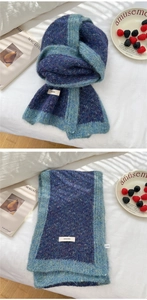 Detail of knitted winter scarf with navy purple body and contrasting light green borders