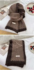 Close-up of two-tone knitted winter scarf with soft brushed texture and brand label