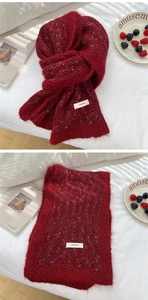 Close-up of deep red knit scarf with fluffy mohair texture and premium logo label