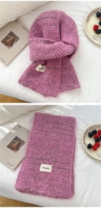 Detail of rose pink and brown chunky knit scarf with premium logo tag texture