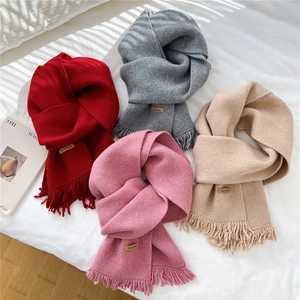Soft knitted scarves with fringe and handmade labels in red, grey, pink, and beige