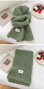 Detail of soft grass green knitted scarf with fluffy mohair texture and brand label