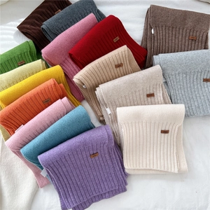 Colorful winter knitted scarves with ribbed texture and decorative leather label