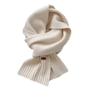 Minimalist cream knit winter scarf with thick wool texture and a leather brand label