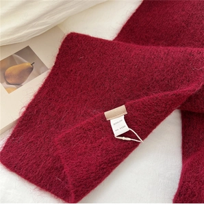 Close-up of wine red wool-blend knitted scarf showing soft texture and cozy fibers