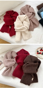 Close-up of assorted chunky knit scarves in various autumn colors with rich wool texture