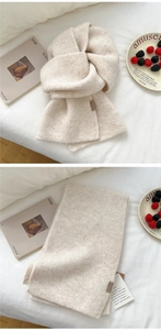 Detail of solid color knitted scarf featuring fine weave and brown leather brand label