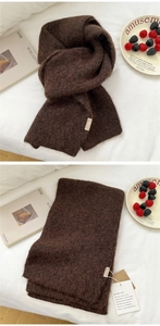 Detail of soft dark brown knit scarf showing plush texture and brand tag with labels