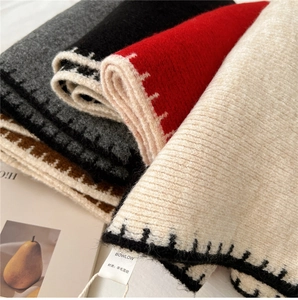 Detailed close-up of wool blend knit scarves with contrast stitching in four neutral colors