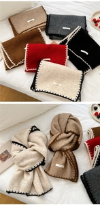 Detail of knitted scarf showing contrasting stitching edge and brand label on fabric