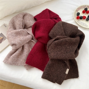 Thick knitted scarves in oatmeal, burgundy and brown on a white fabric background