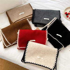 Cozy bicolor knit scarves for women and men featuring contrast stitching and brand label