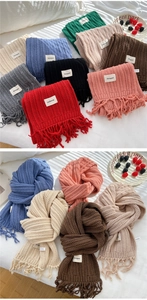 Close-up of chunky knit vertical texture and fringe details on a warm winter scarf