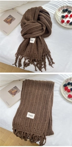 Detail of dark brown chunky knit scarf showing ribbed texture, fringes, and logo label