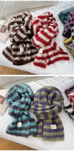 Close-up of soft knitted striped scarves with decorative ins labels on white linen