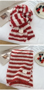 Detail of red and white striped knit scarf with plush texture and small ins fabric label