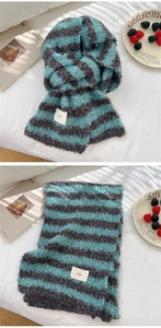 Detail of blue and grey striped knit scarf with a stylish ins woven label on soft fabric