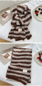 Close-up of fluffy brown and white striped knit scarf with a stylish ins logo label
