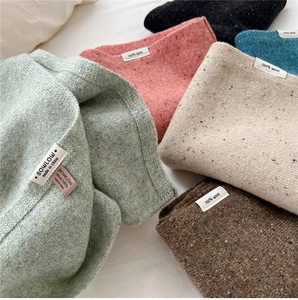 Detail of colorful knitted 100% wool scarves with premium brand label and soft texture