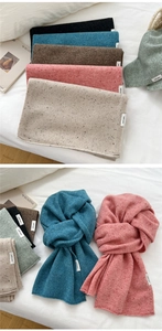Close-up of 100% wool knit scarves with speckled yarn texture and authentic label