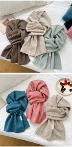 Detail of colorful knitted 100% wool scarves with soft flecked texture and white woven label