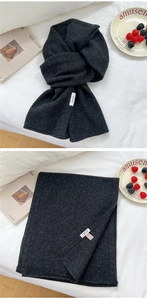 Detail of 100% pure wool knitted scarf in dark grey marl with soft texture