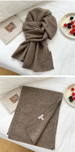 Detail showing 100% wool material texture of a dark brown speckled knitted scarf