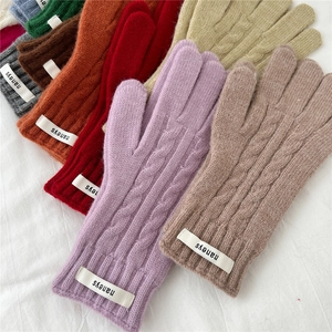 Primer plano de guantes de punto trenzado de varios colores con etiquetas tejidas