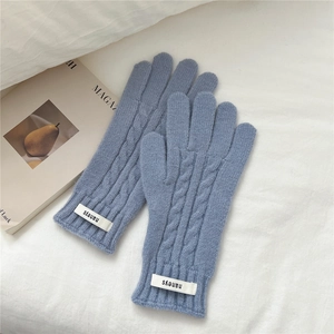Primer plano de guantes de punto de ochos azul grisáceo con detalle de logo y función táctil