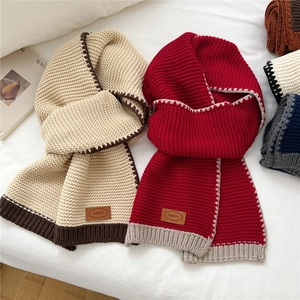 Chunky knit scarf with contrasting scalloped edges and leather brand patch for winter