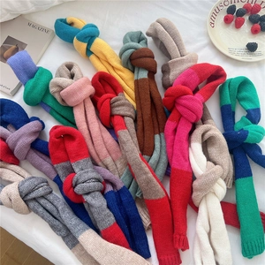 Flat lay of colorful knit scarves featuring vibrant contrast color stitching and thick textures