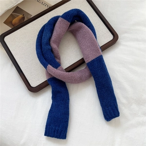Detail of the soft knit texture and contrast color block design on the narrow winter scarf