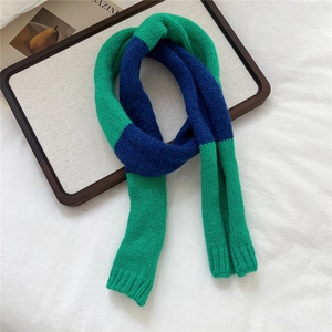 Macro detail of high-quality green and blue color-blocked knit texture on a winter scarf