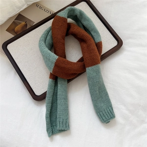 Detail of color-block knit scarf in forest green and brick red with ribbed edges