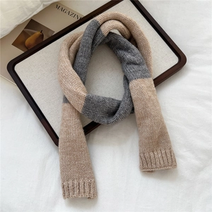 Close-up of oatmeal and grey color-block knit scarf with ribbed edges on a tray