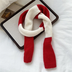 Macro detail of red and white color-block knit scarf with soft ribbed edges and thick texture