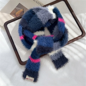 Detailed view of colorful plush knit scarf with soft stripes and brand logo tag