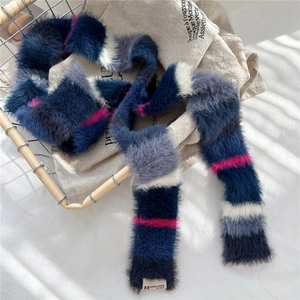 Close-up of a soft colorful striped plush scarf with an elegant designer woven label