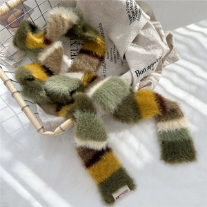 Close-up of a warm colorful striped faux fur scarf in a vintage metal basket