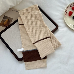 Detail of chunky knit striped scarf with ribbed edge on a tray for cozy style