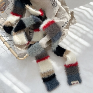 Macro detail of colorful striped plush scarf with thick faux fur texture and brand label