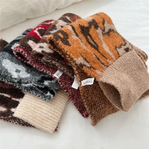 Detailed view of leopard and tiger print knitted scarves showing soft plush texture