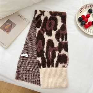 Macro detail of knit leopard scarf showing ribbed edge and soft textured fabric