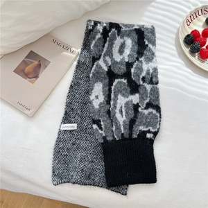 Close-up of leopard pattern knit scarf with ribbed cuff and quality fabric tag