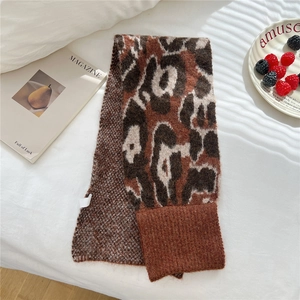 Macro detail of leopard print knitted scarf with ribbed edges on a white background