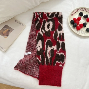 Detailed close-up of leopard print knitted scarf with ribbed edge and woven texture
