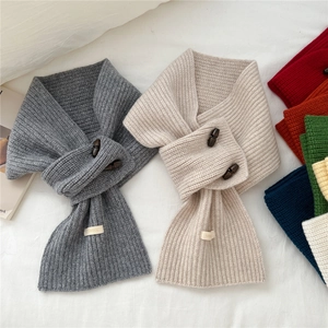 Écharpe en laine tricotée avec boutons en corne en plusieurs couleurs sur tissu blanc