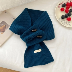 Détail de l'écharpe en laine tricotée bleu marine avec boutons en bois et étiquette